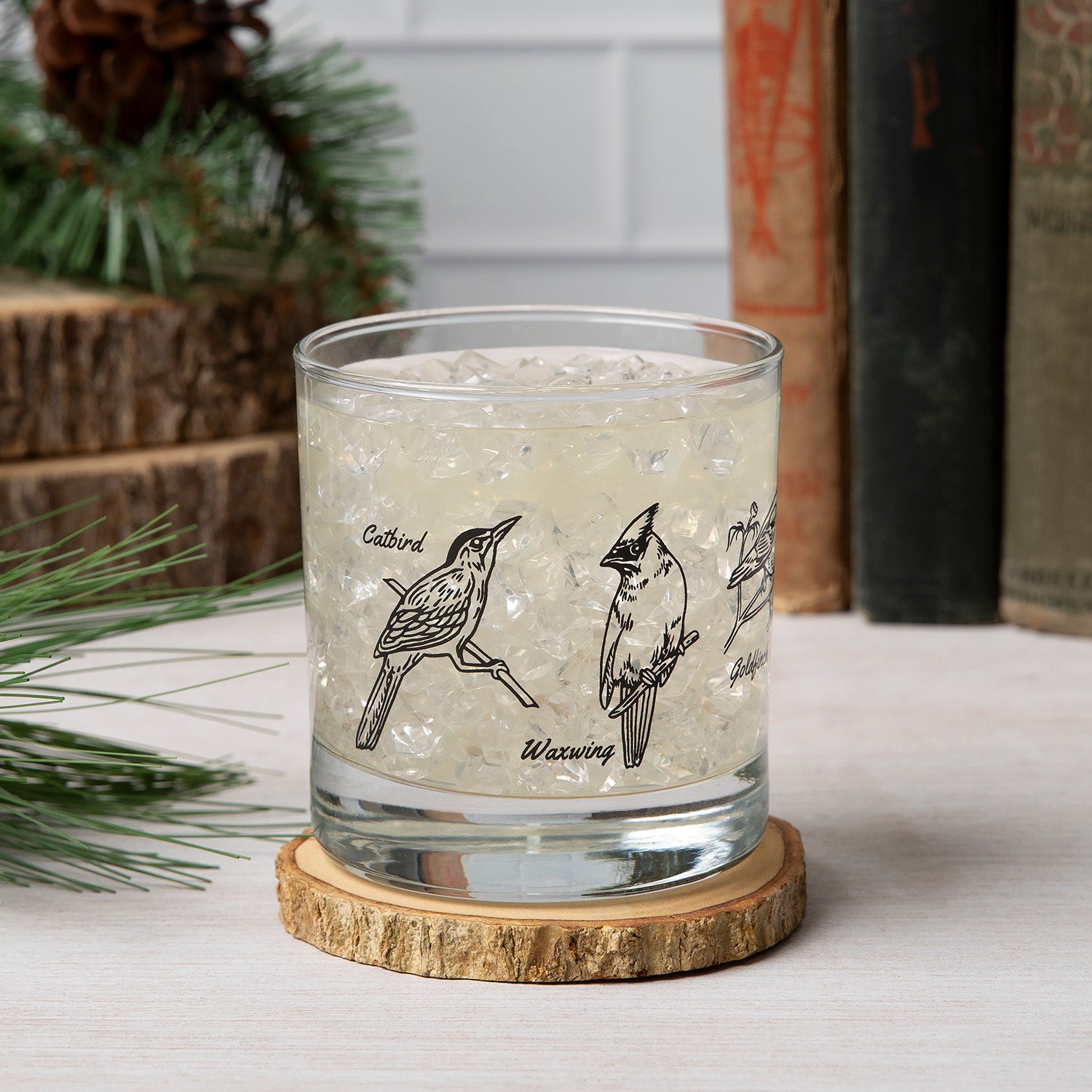 Enjoy a beverage in the stylish Birds Rocks Glass from Counter Couture featuring beautiful backyard birds wrapped around the glass, perfect for cocktails.