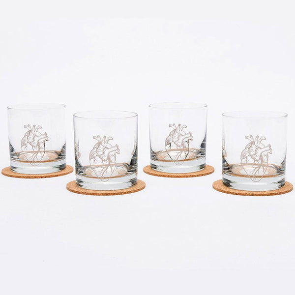 Set of four heart whiskey glasses on coasters with a white background.