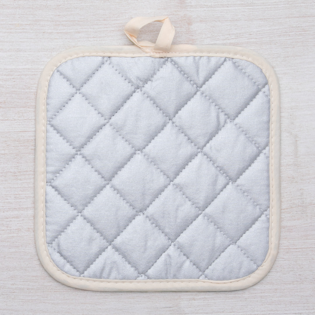 Sasquatch Pot Holder hanging with convenient fabric loop, showcasing its heat-resistant backing and playful design.