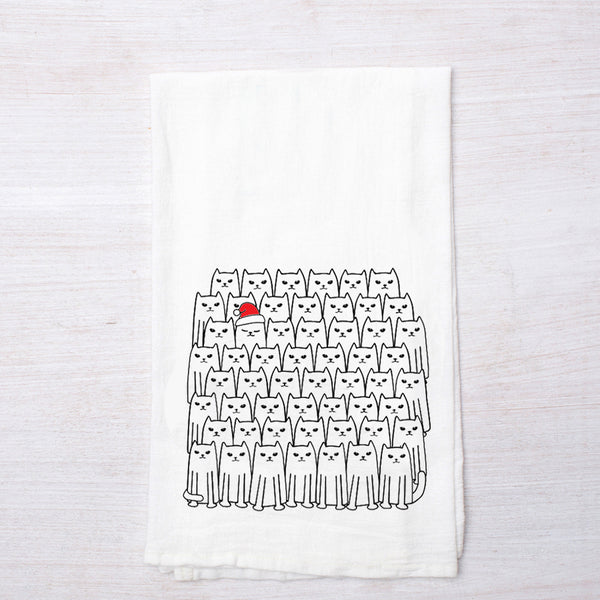 Counter Couture Santa Cats flour sack towel lying flat, showcasing a fun pattern of cats, with one cat prominently wearing a red Santa hat.