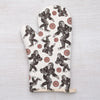 Stylish Sasquatch Oven Mitt displayed with kitchen utensils, highlighting its fun and functional design.