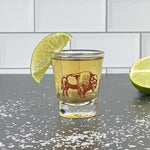 Shot glass with bison graphic, filled with liquor, garnished with lime, on salted counter