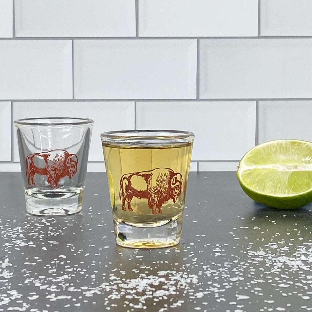 Bison print shot glass filled with liquor, lime half, and salt on a modern bar counter
