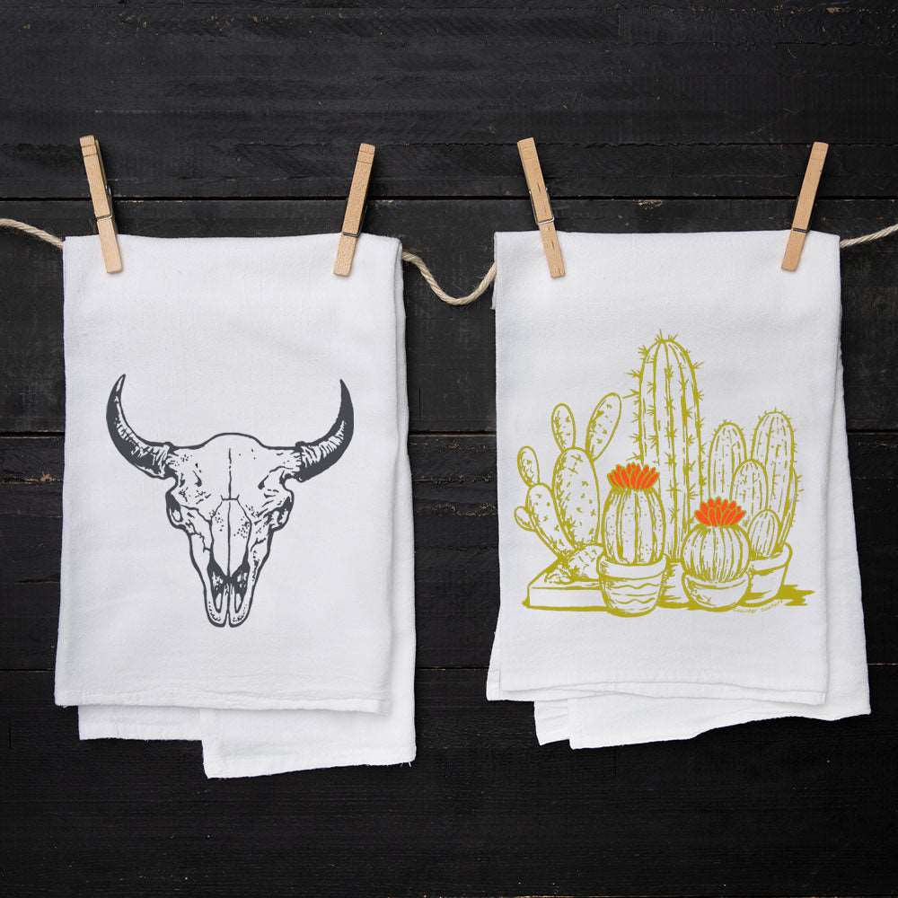 Set of two white kitchen towels featuring a buffalo skull and potted cactus illustrations