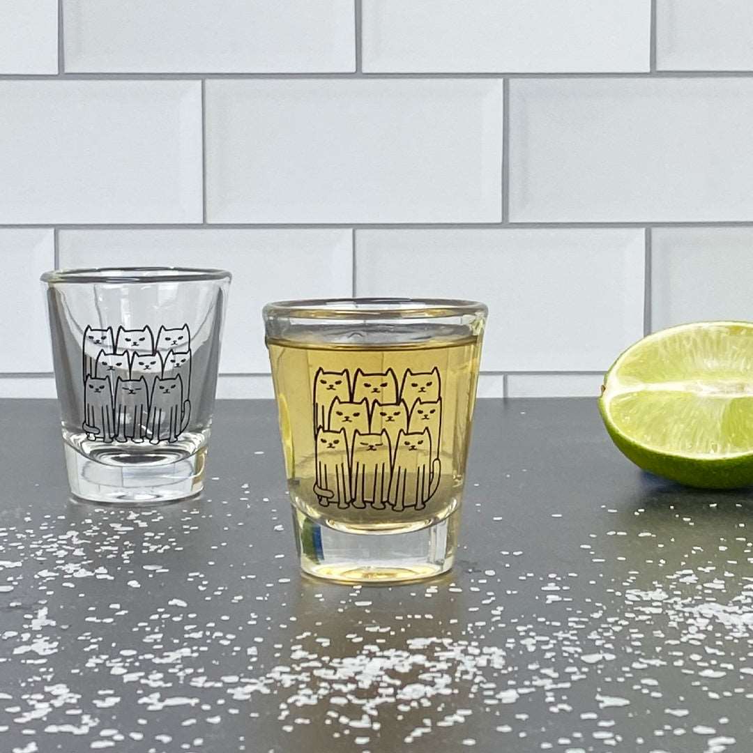Cat-themed shot glasses on a kitchen counter with lime and salt, fun barware gift