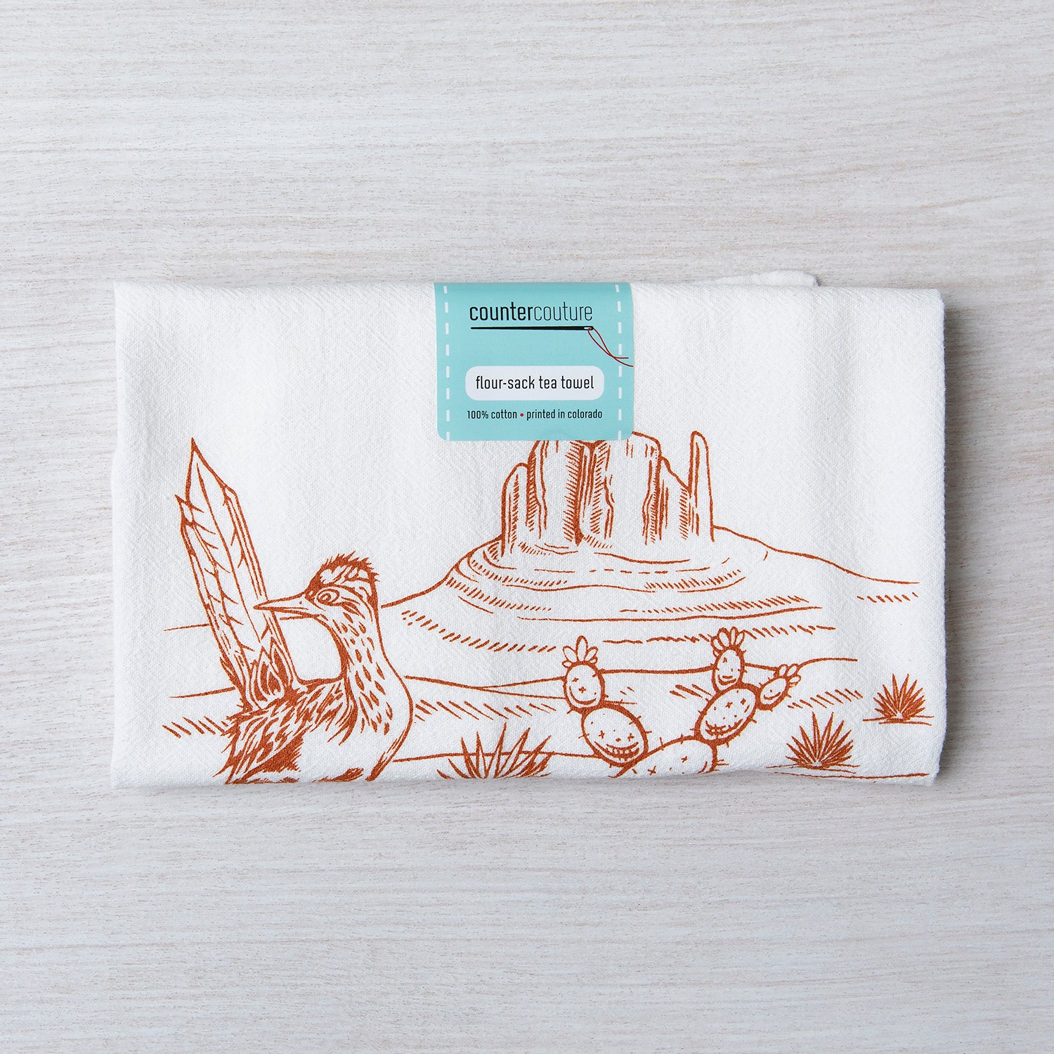 Desert-themed flour sack tea towel with cactus and roadrunner illustration on white cotton.