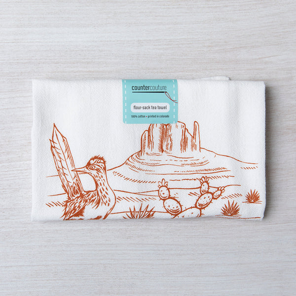Desert-themed flour sack tea towel with cactus and roadrunner illustration on white cotton.