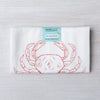 Folded Dungeness Crab flour sack tea towel by Counter Couture, displaying a red crab design with a tag indicating 100% cotton, perfect for kitchen use.