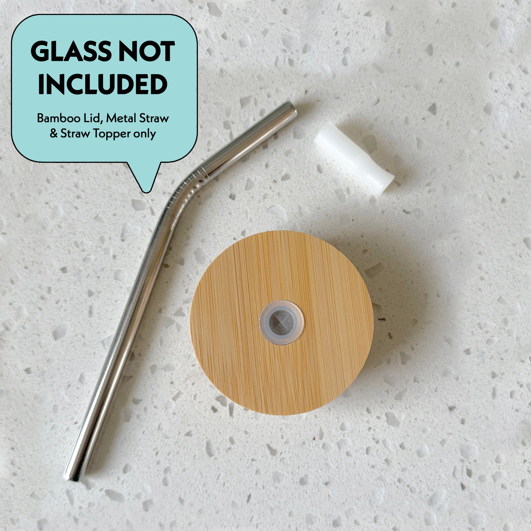 Bamboo lid, metal straw, and straw topper on a white countertop, glass not included