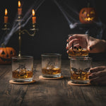 Macabre Halloween rocks glasses styled with jack-o-lanterns, candles and cobwebs