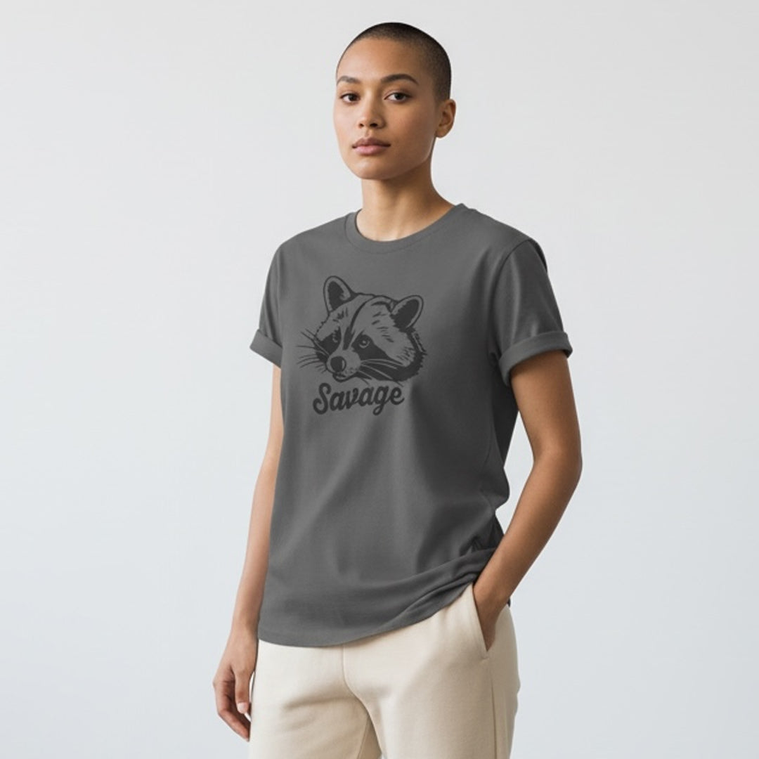 Woman wearing a gray graphic t-shirt with a raccoon face and 'Savage' text design.
