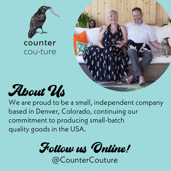 Smiling couple with dogs on a sofa, About Us graphic for small independent home goods store.