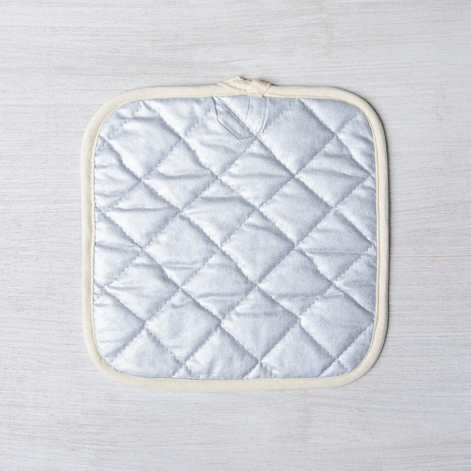 Close-up of the Saguaro Pot Holder fabric, featuring its stylish cactus patterns and convenient fabric loop for easy hanging.