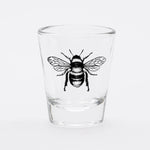 Clear shot glass with a detailed black bee illustration on the front