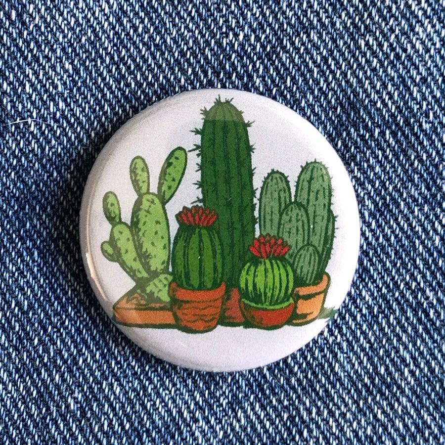 Round cactus button with colorful potted cactus illustration on denim fabric background