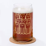 Beer can glass with cute cat illustration, filled with amber beer on a cork coaster