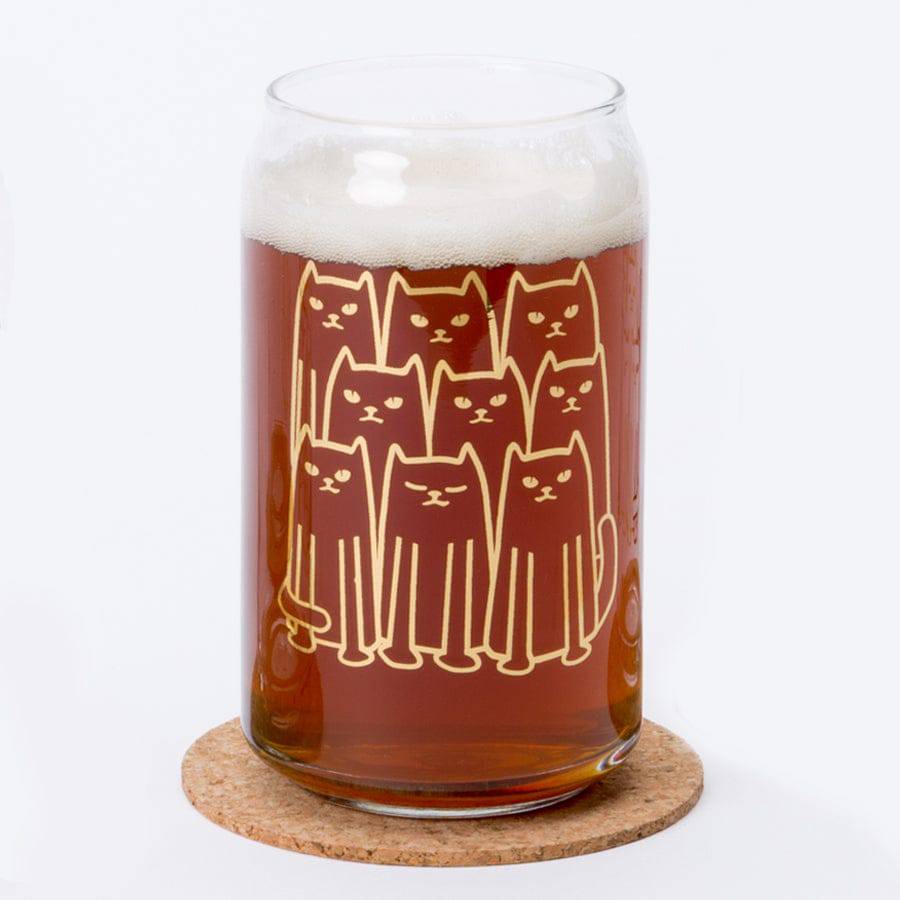 Beer can glass with cute cat illustration, filled with amber beer on a cork coaster