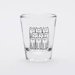 Clear shot glass with a cute black line art illustration of nine cats