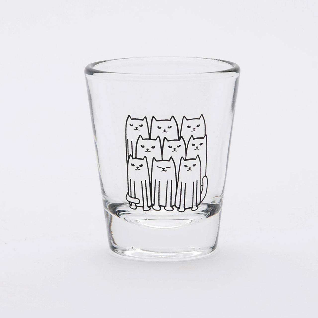Clear shot glass with a cute black line art illustration of nine cats