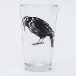 Pint glass with black crow illustration, unique barware on white background