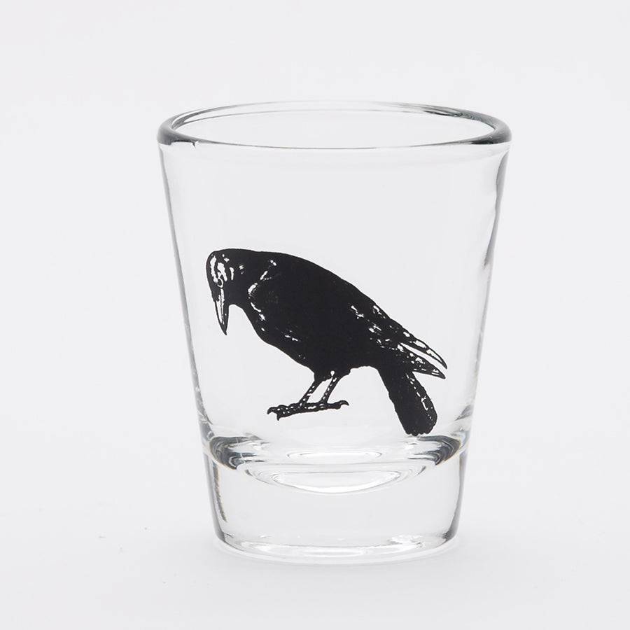 Clear shot glass with black crow illustration on white background, unique barware gift