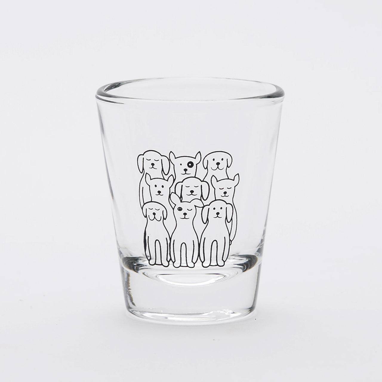 Clear shot glass with a cute line drawing of nine dogs on white background