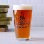Pint glass of beer with a gnome and mushroom illustration, whimsical barware design