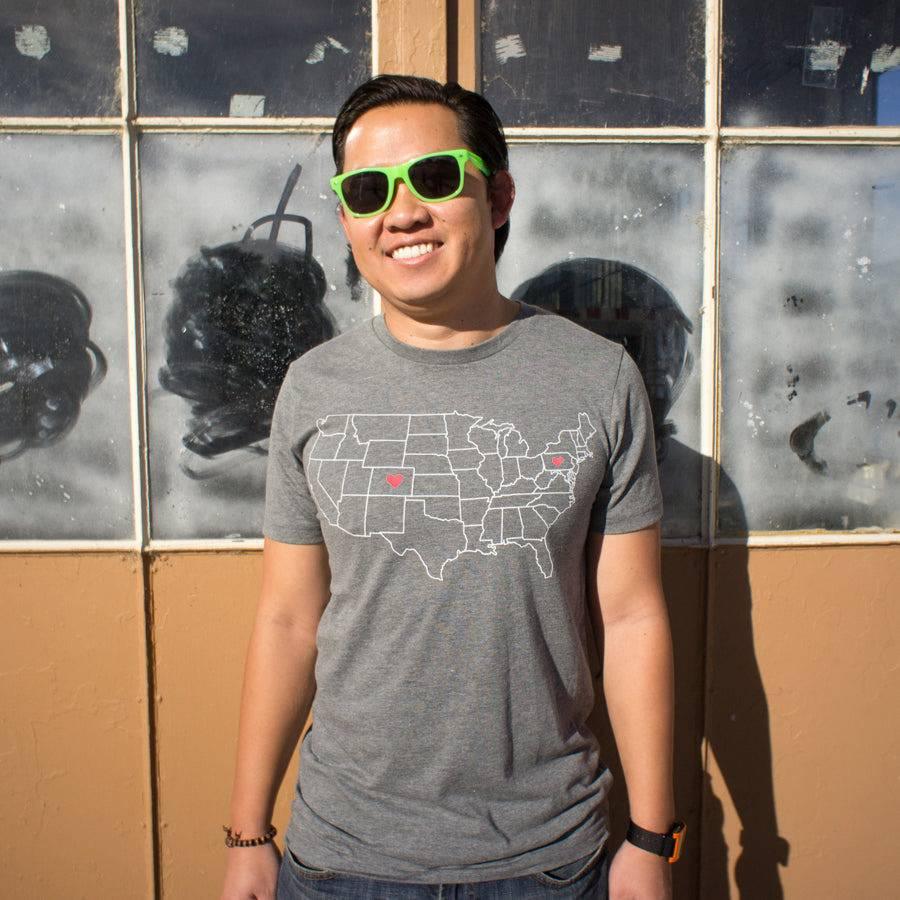 Man in sunglasses wearing a gray USA map graphic t-shirt with heart icons