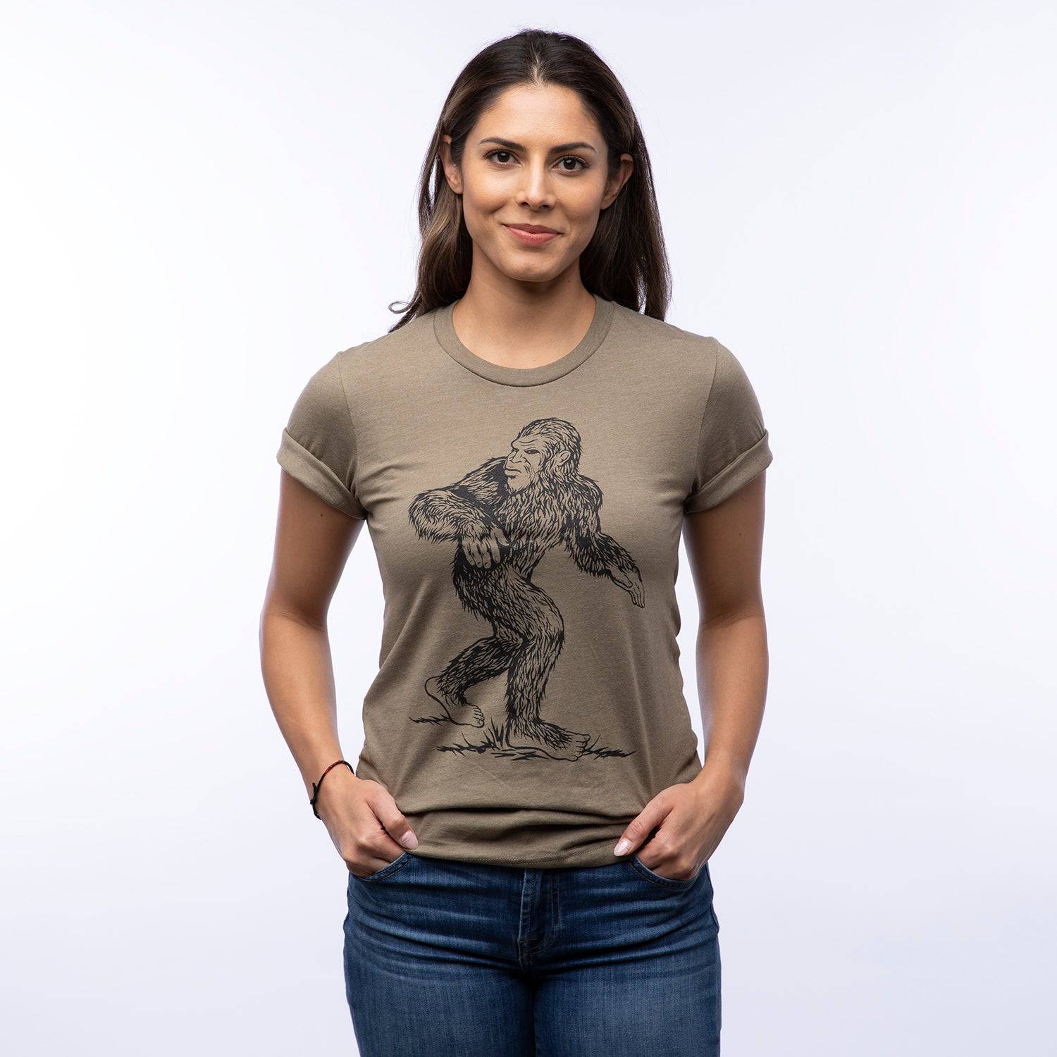 Woman wearing khaki graphic tee with Sasquatch Bigfoot illustration, casual style