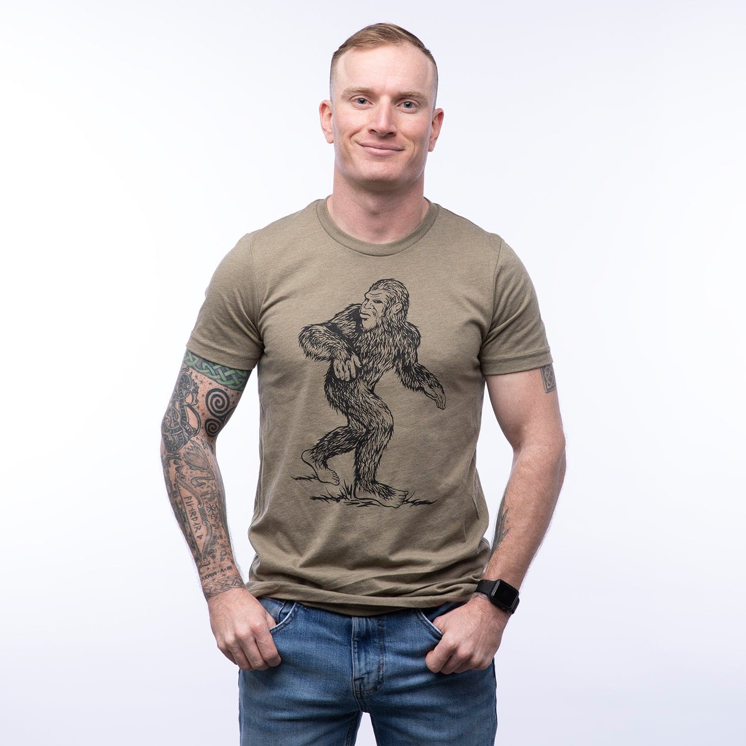 Man wearing khaki graphic t-shirt with Sasquatch illustration, casual style