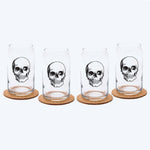 Set of four clear can-shaped glasses with black skull design on cork coasters