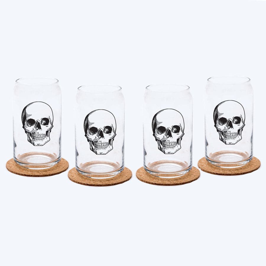 Set of four clear can-shaped glasses with black skull design on cork coasters