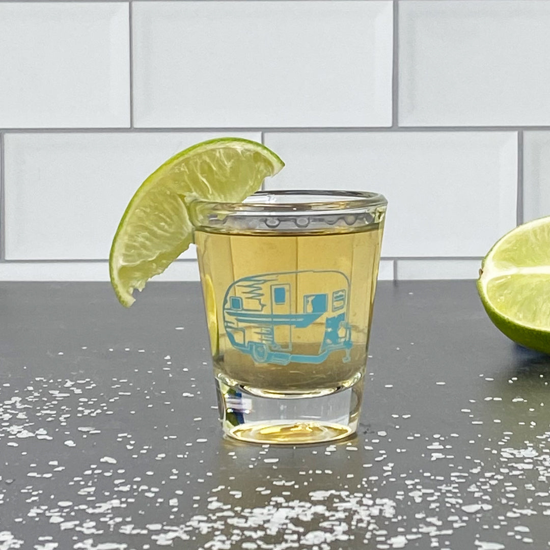 Camper trailer shot glass with tequila, lime wedge garnish, and salt on a dark countertop